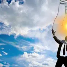 Man holding light bulb in the sky